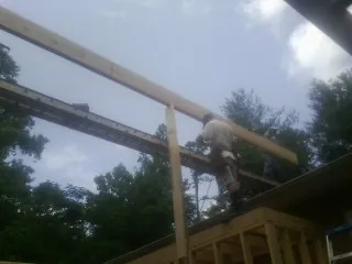 Carpenter setting a ridge beam over a new addition frame — Ice Dam Removal by Roofing Brothers in Niantic