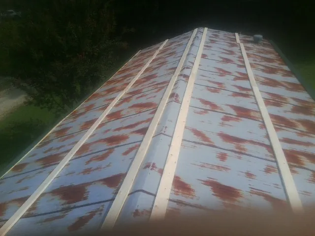 Rusted metal roof panels with new wood purlins before replacement — Storm Damage Roof Repair in Niantic by Roofing Brothers