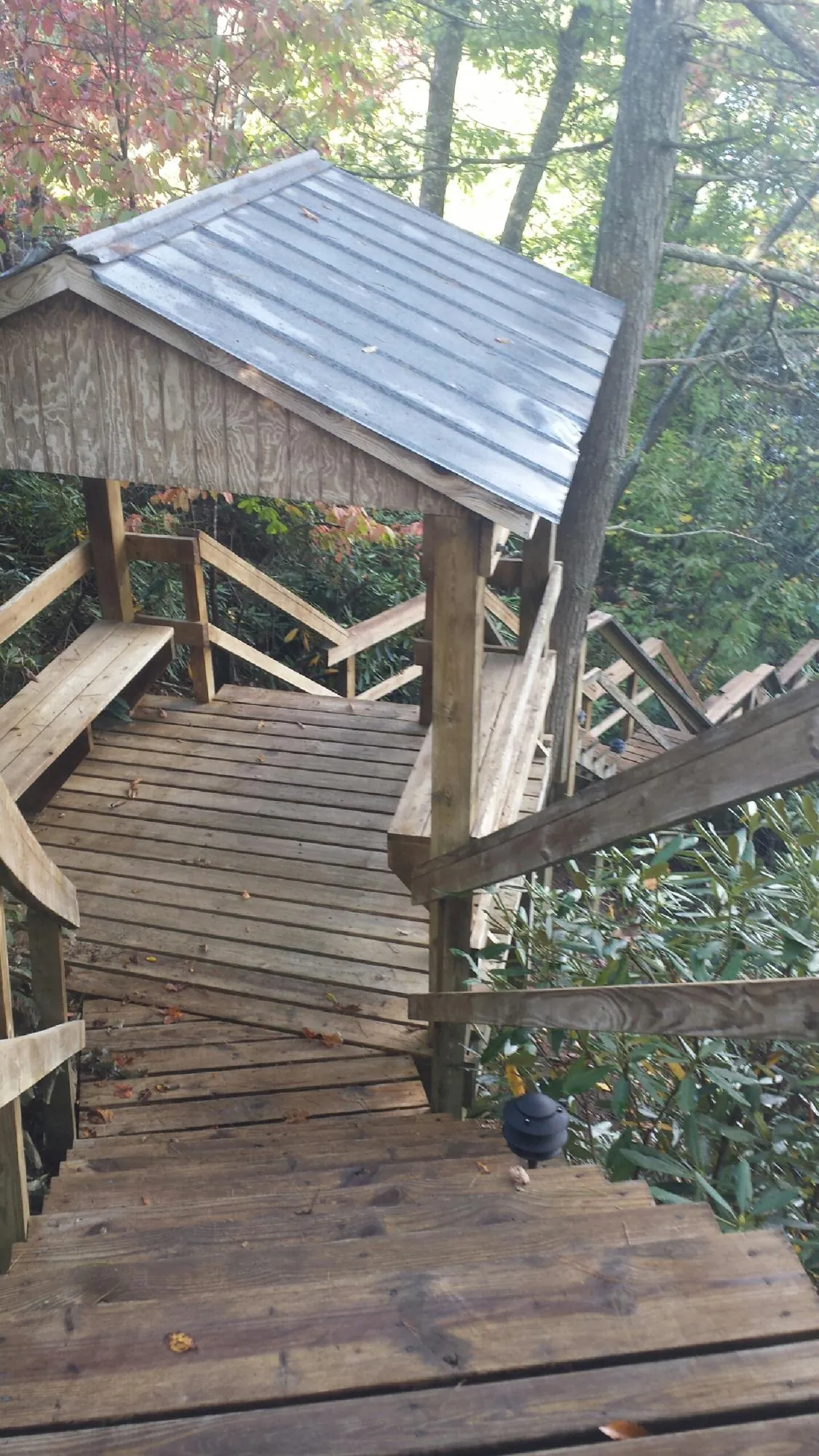 Metal roofed shelter over wooden steps on a wooded walkway — Skylight Repair & Installation work by our crew in Niantic